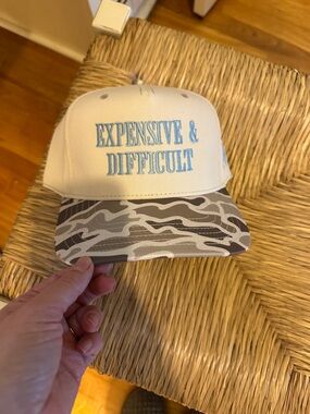 "Expensive & Difficult" Embroidered Trucker Hat - Cream with Gray Camo Bill
